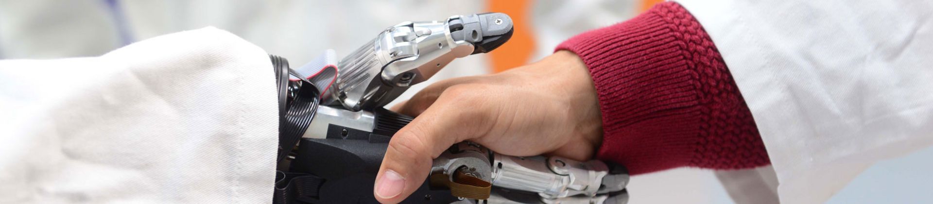 Plan serré recadré d'une poignée de main entre un robot et un humain dans un laboratoire