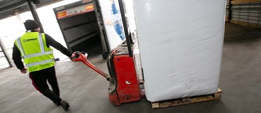 Personne tirant un chariot dans l'entreprise de transports Hunault.